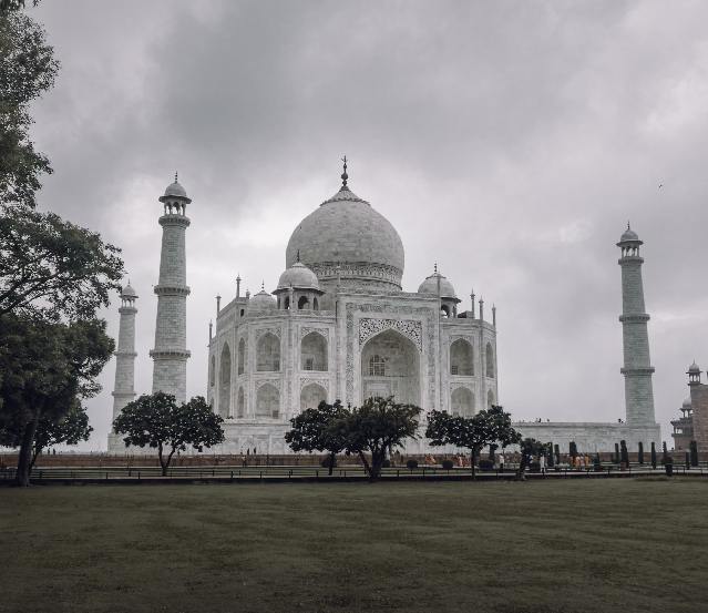 A breathtaking view of the Taj Mahal in Agra, one of the world’s most iconic monuments, surrounded by lush gardens and reflecting pools. This image captures the essence of Agra, ideal for Agra tour packages, showcasing the best time to visit Agra for a memorable experience. It highlights Agra’s rich history, including its Mughal heritage, and hints at the famous food of Agra, such as petha and kebabs. It also offers a glimpse of how to reach Agra, making it the perfect destination for history and culture enthusiasts.